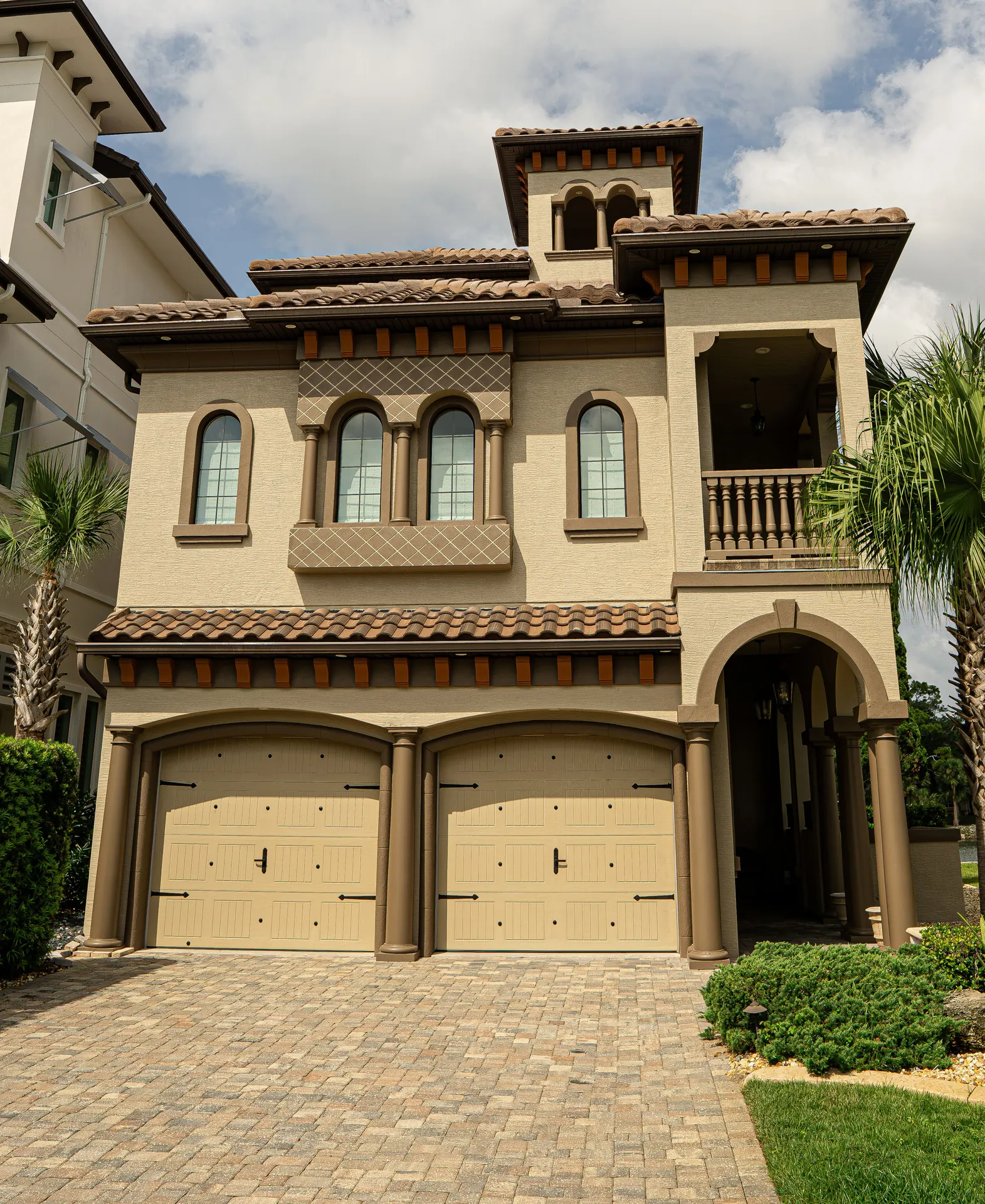 Mediterranean-inspired luxury home with a landscaped motor court