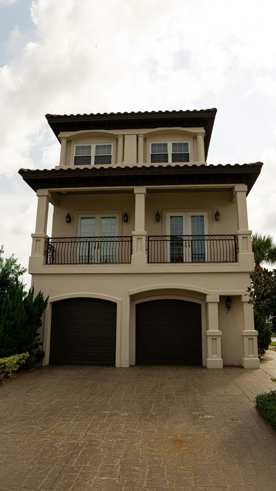 Luxury custom home framed by palms and mature landscaping