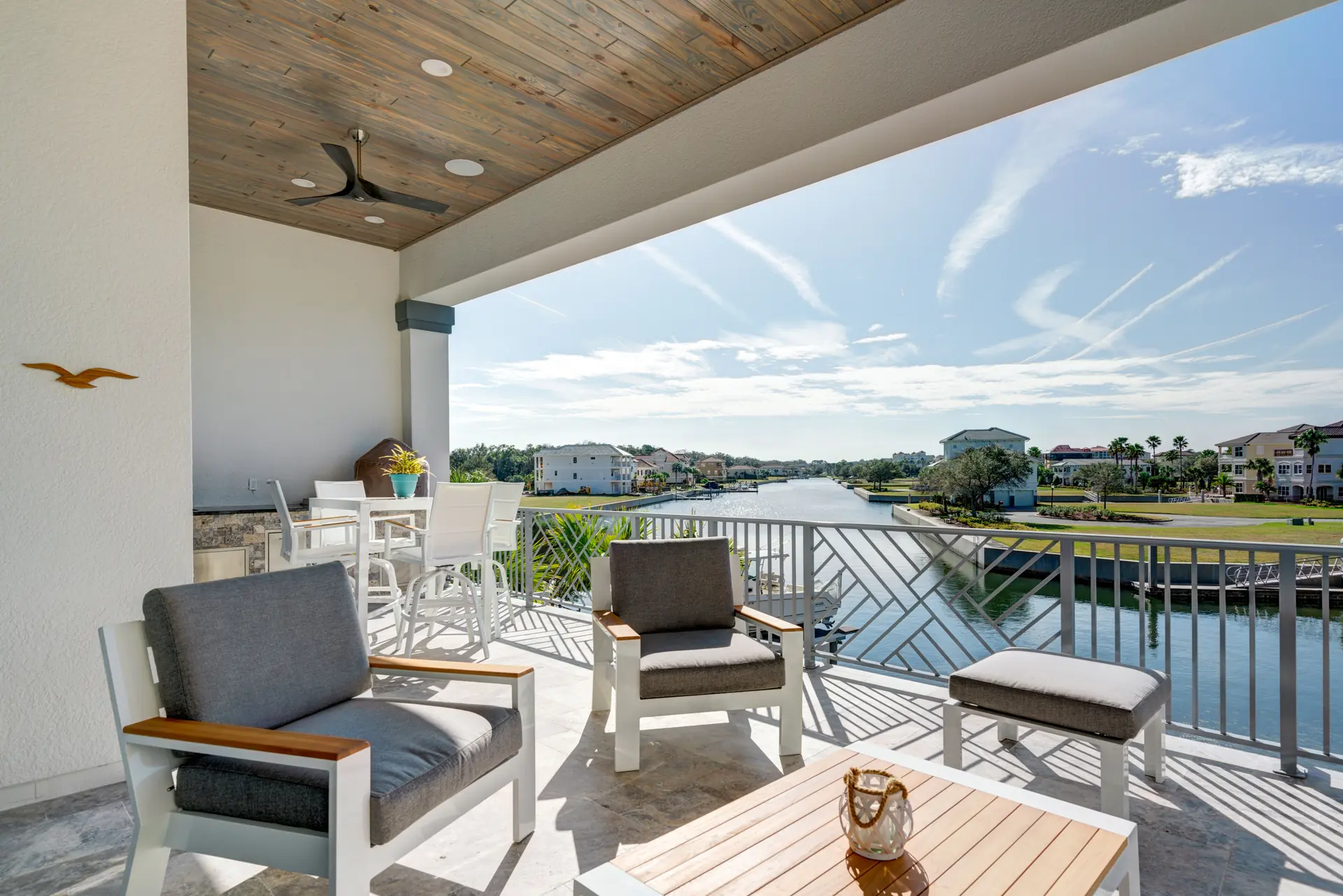 Covered balcony with wide water views and wood ceiling