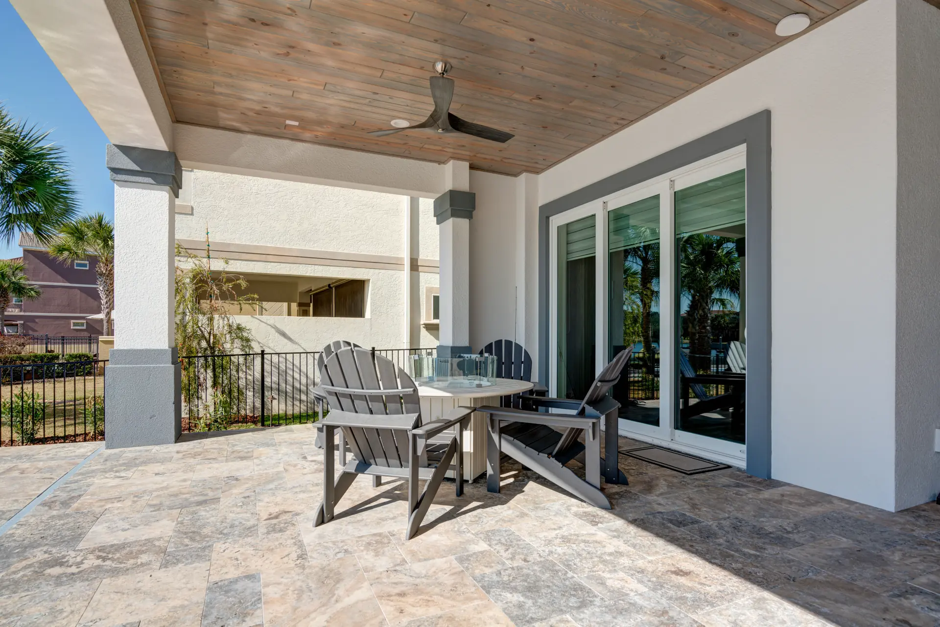 Covered pool patio with warm wood ceiling and outdoor seating
