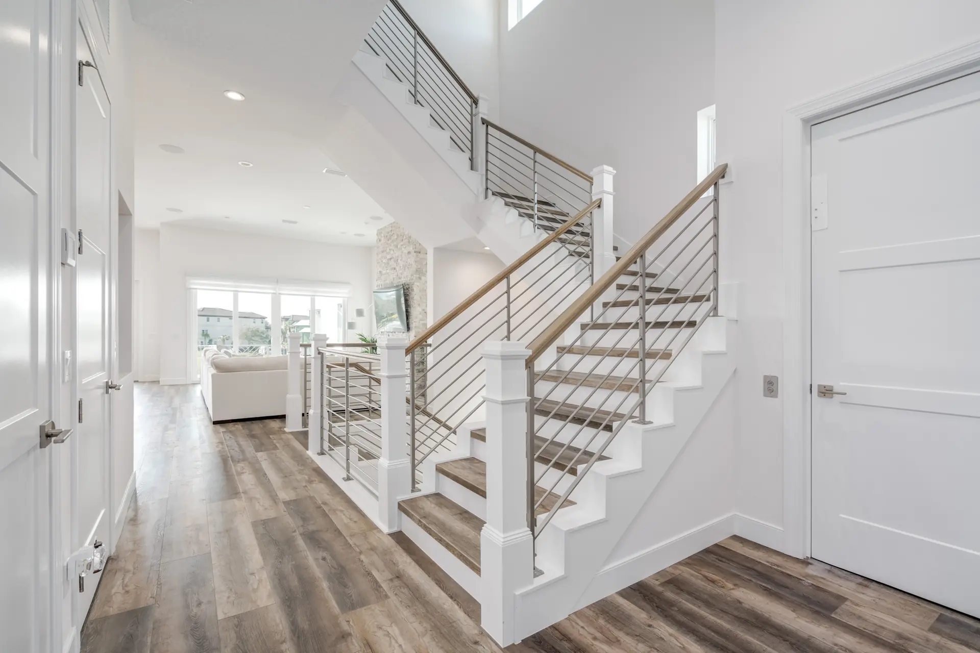 Custom open staircase with metal railings and coastal finishes