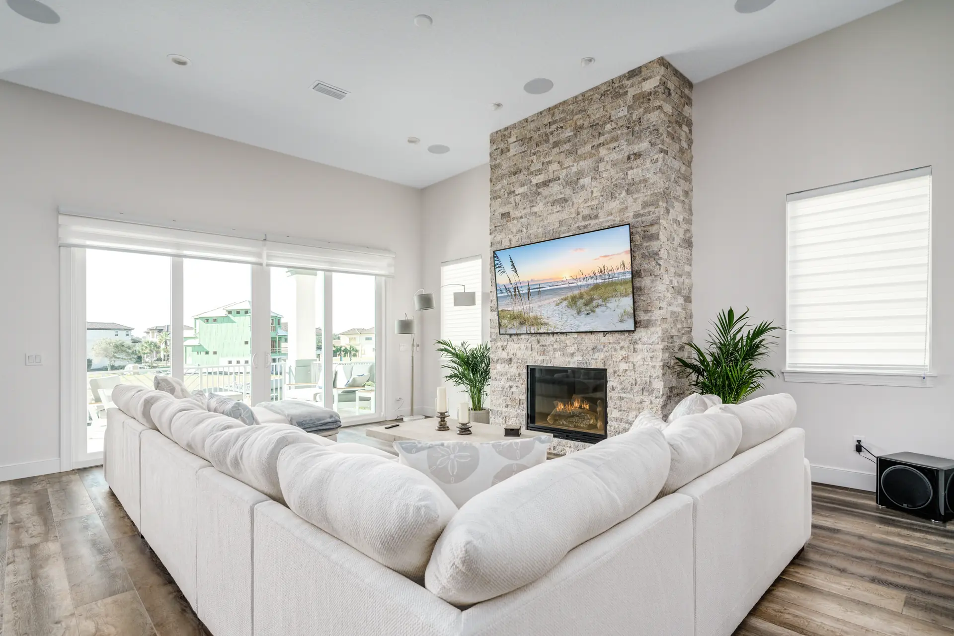 Bright great room centered on a floor-to-ceiling stone fireplace