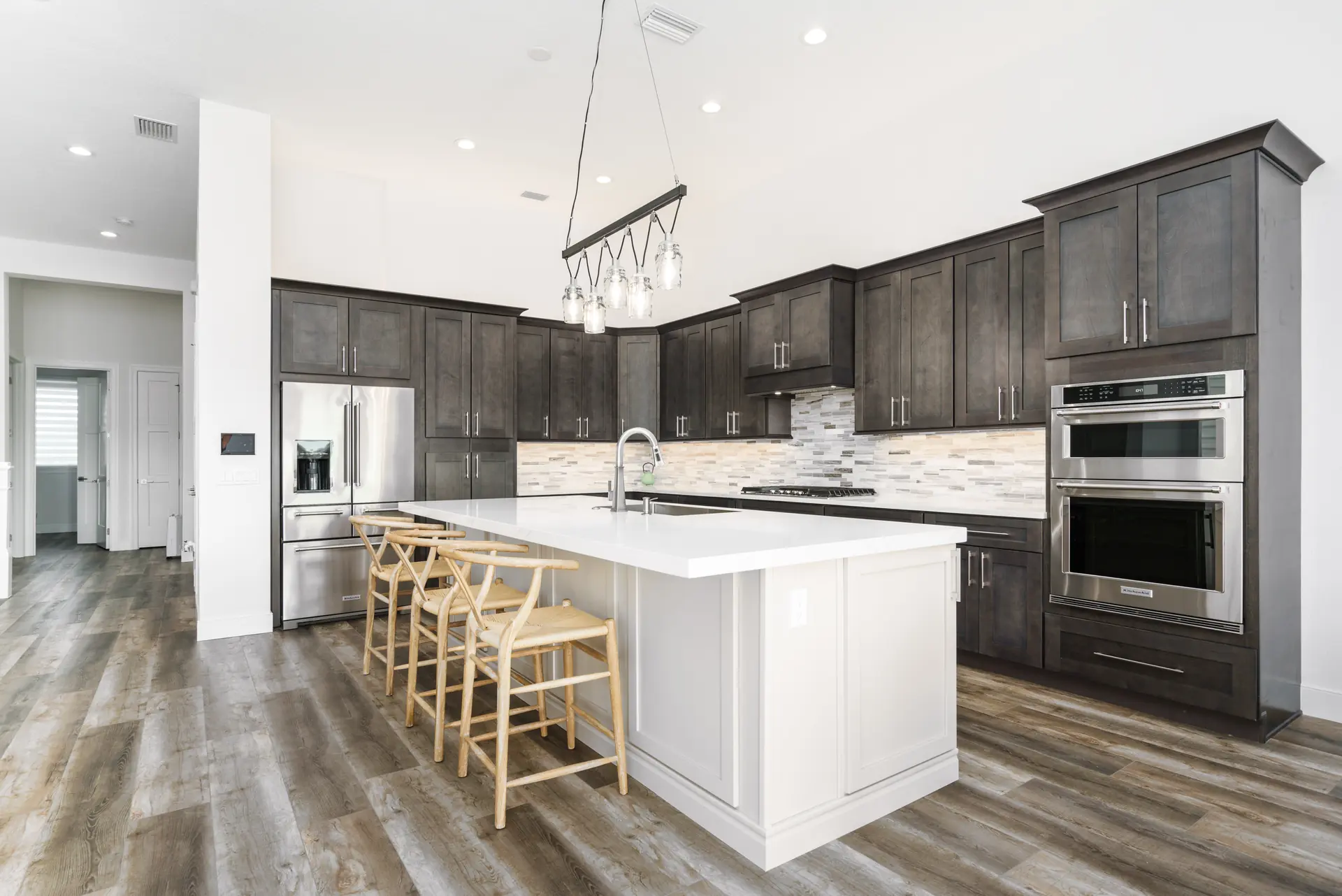 Custom kitchen with dark cabinetry and contrasting white island
