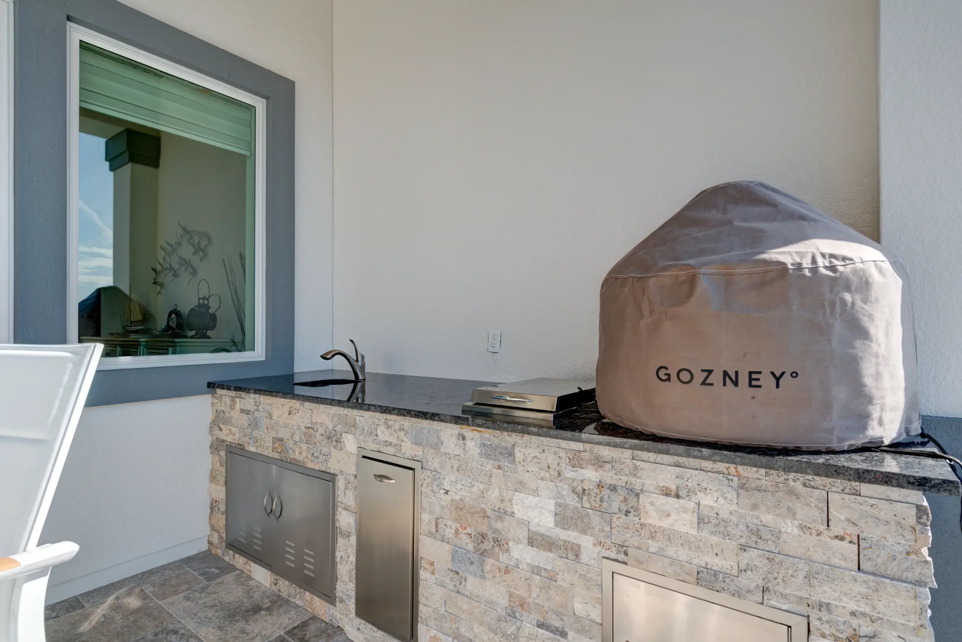 Stone-clad outdoor kitchen on a covered waterfront terrace