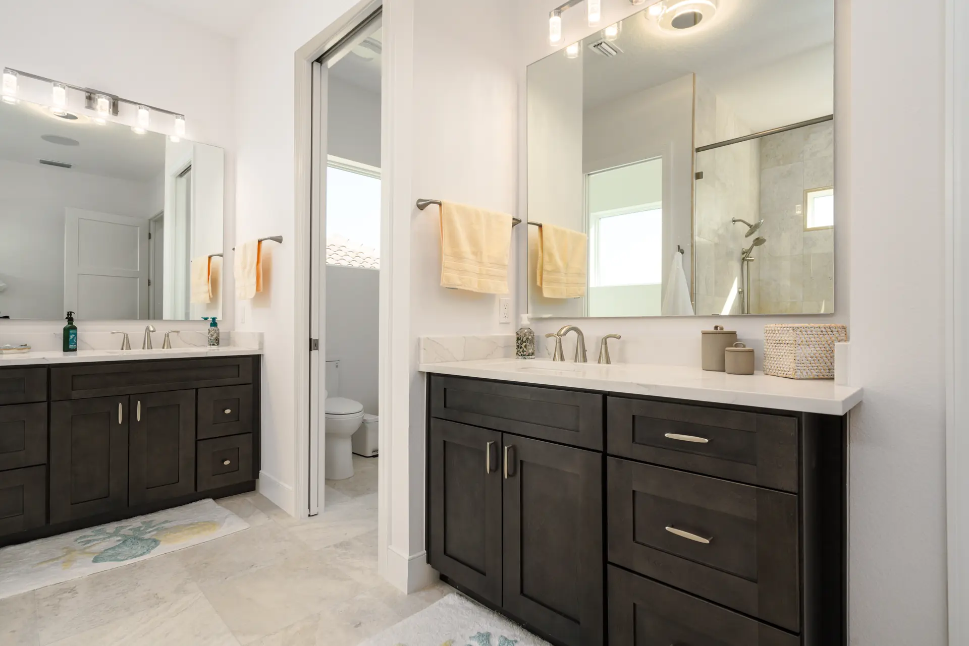Primary bathroom with dark wood double vanity and oversized mirrors