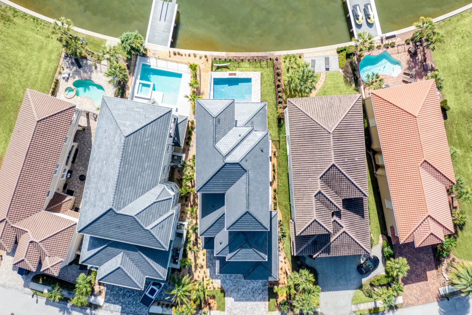 Top-down aerial view of a waterfront home's roofline and pool
