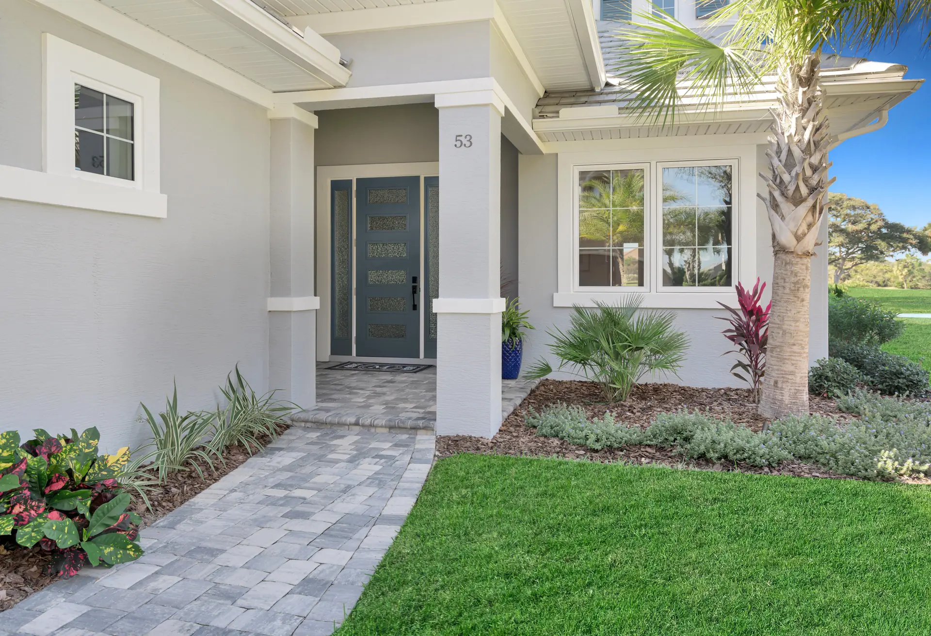 Welcoming garden entry with paver walk and tailored landscaping