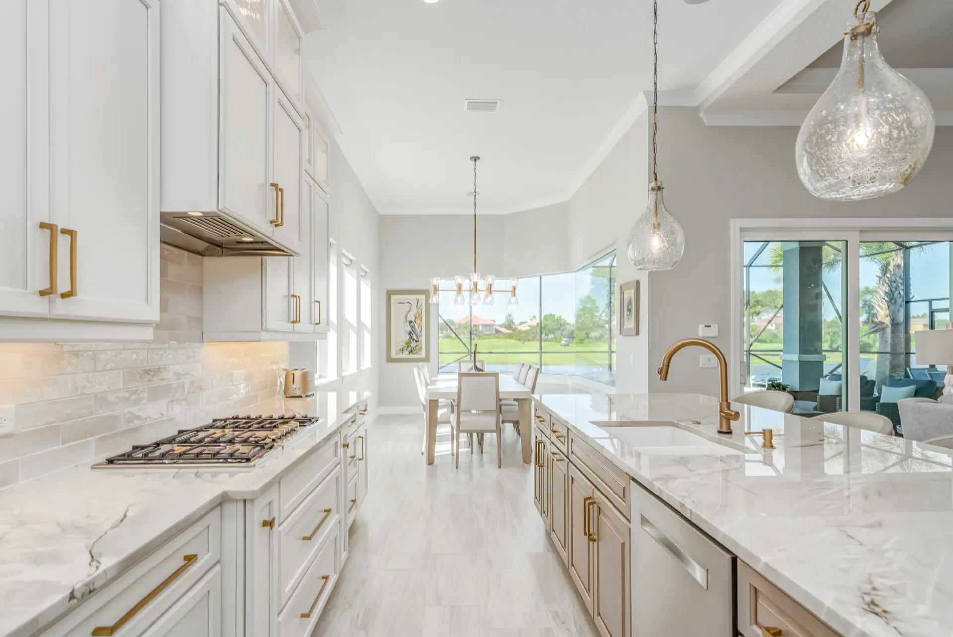 Bright galley kitchen with white cabinetry and brass accents
