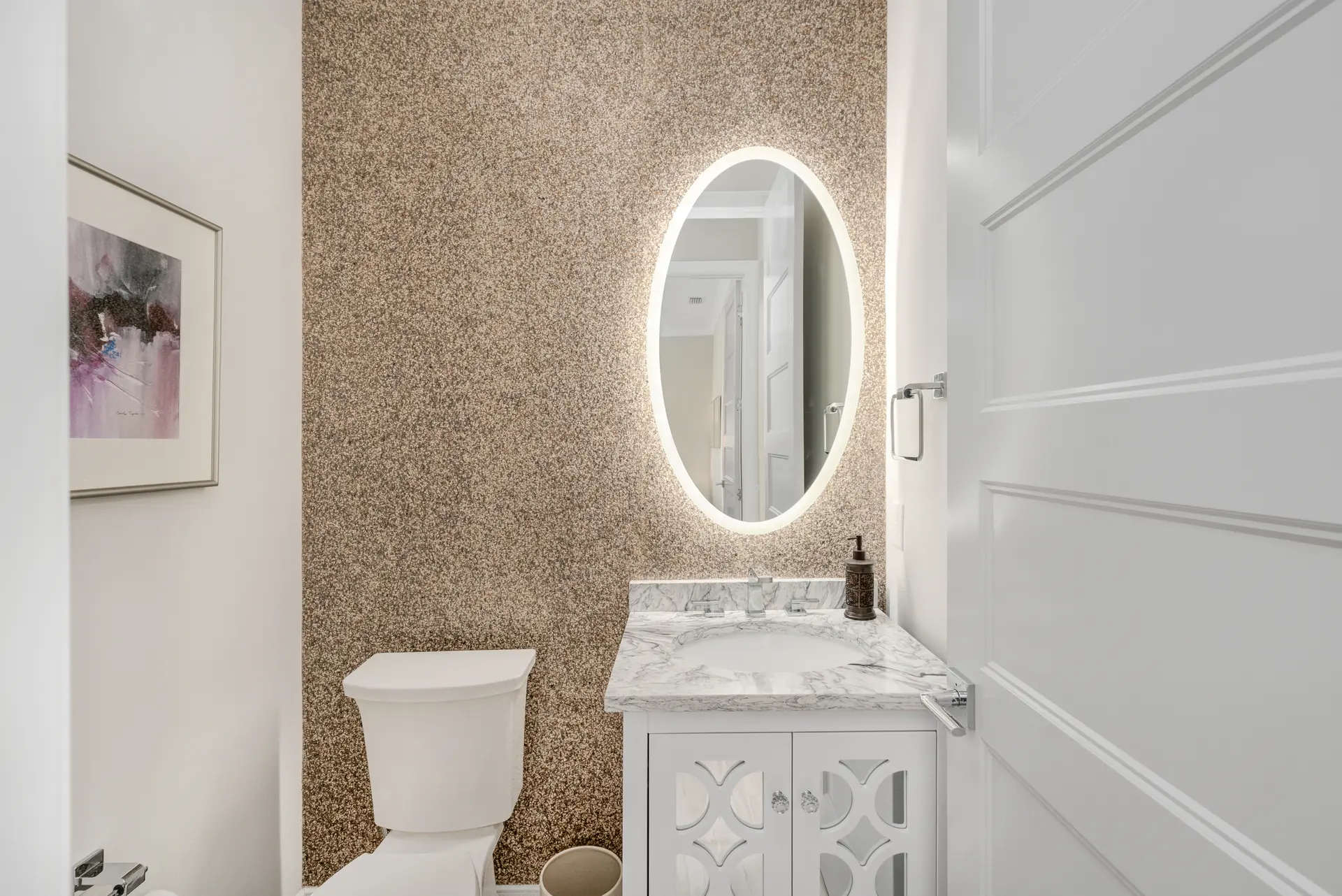 Powder room with textured wall finish and illuminated mirror